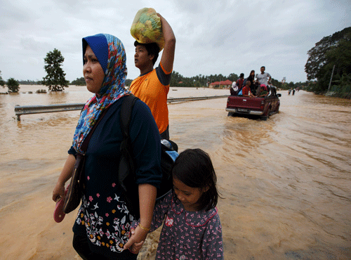 People carry their belongings as they evacuate through a flooded street, on the outskirts of Kota Bharu in Kelantan. Reuters file photo