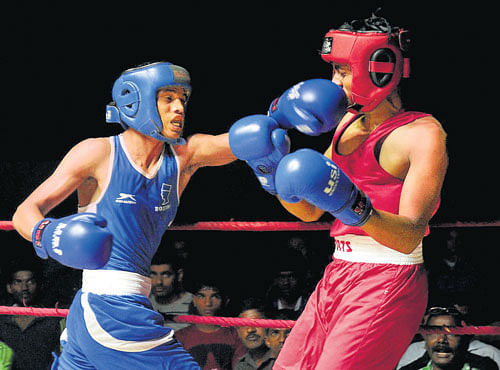take that: MEG's M Srinivas (left) delivers a solid punch to SAK's Pradeep in the Men's junior Light welter category during the State Boxing Championship at the Sree Kanteerava Indoor Stadium in Bengaluru on Wednesday. Srinivas won the bout. dh photo