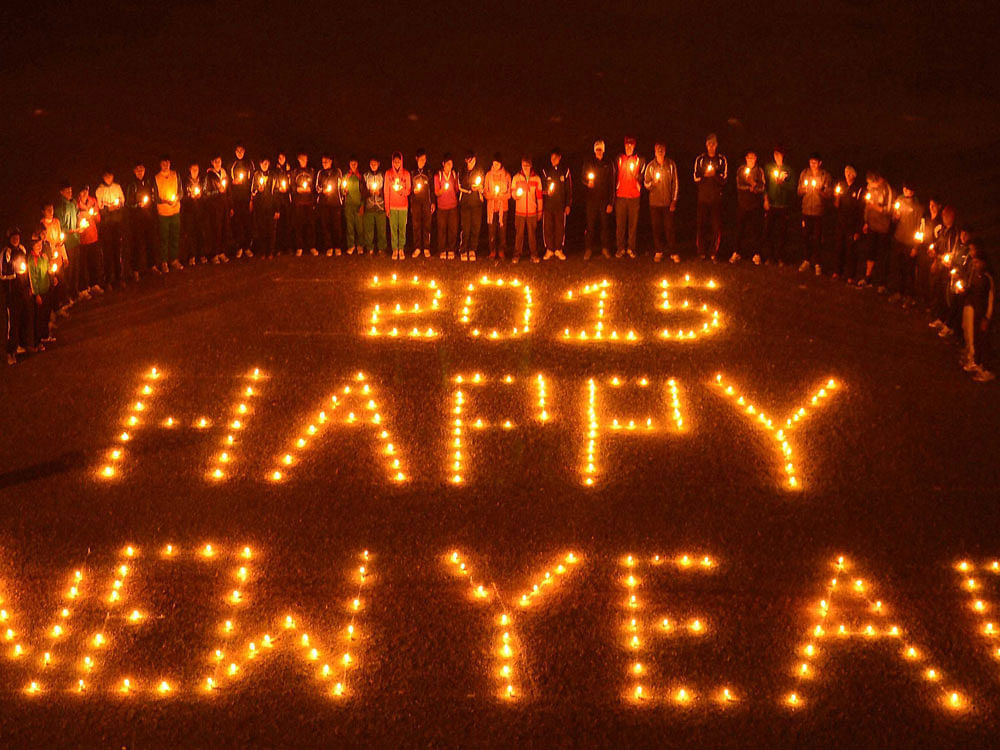People light candles forming the words 'Happy new year 2015' on New Year's eve in Allahabad.  PTI photo