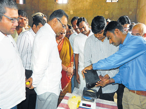 Food and Civil Supplies Minister Dinesh Gundu Rao inspects the paddy grading process at TAPCMS procurement center, in Maddur, Mandya district, on Saturday. DH PHOTO