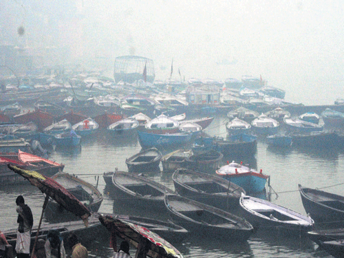 Boats anchored during a foggy and rainy day in Varanasi on Saturday. PTI