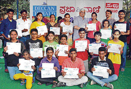 Winners of the Deccan Herald-Prajavani painting contest, organised as part of Chitra Santhe strike a pose with their certificates.