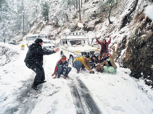 Tourists on a snow-covered road in Uttarakhand on Sunday. PTI