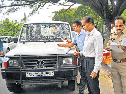 Regional Transport Officer K T Halaswamy, along with other officials, checks documents of government vehicles at  Cubbon Park in Bengaluru on Tuesday.  DH Photo/ Vishwanath Suvarna