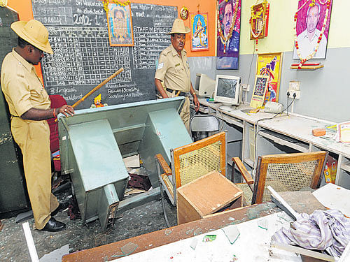 assessing the damage: Police inspect the vandalised classrooms of the school at Hosaguddadahalli on Thursday. DH photo