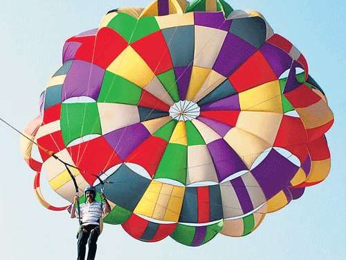Additional Deputy Commissioner H N Gopalakrishna goes parasailing, one of the attractions at the Hoysala Utsav this year, at Buvanahalli, near Hassan, on Thursday. DH PHOTO