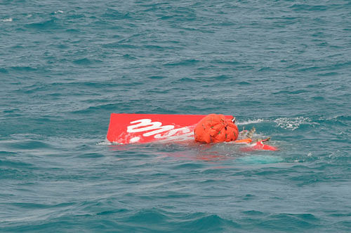 Part of the tail of AirAsia QZ8501 floats on the surface after being lifted as Indonesian navy divers conduct search operations for the black box flight recorders and passengers and crew of the aircraft, in the Java Sea. Reuters photo