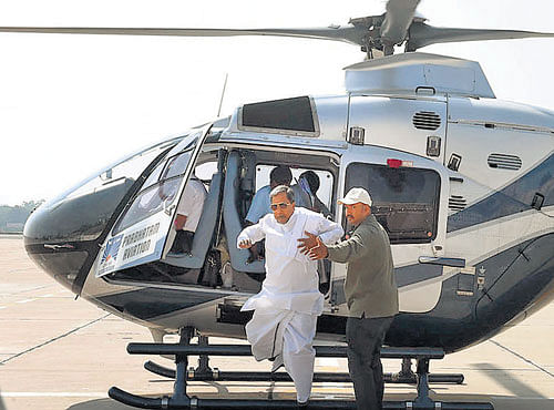 Chief Minster Siddaramaiah rushes out of the helicopter after being told that there was a spark in one of its parts, at HAL Airport in Bengaluru on Saturday. DH PHOTO