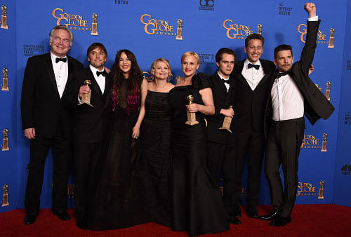 Jonathan Sehring, from left, Richard Linklater, Lorelei Linklater, Cathleen Sutherland, Patricia Arquette, Ellar Coltrane, John Sloss and Ethan Hawke pose in the press room with the award for best motion picture - drama for