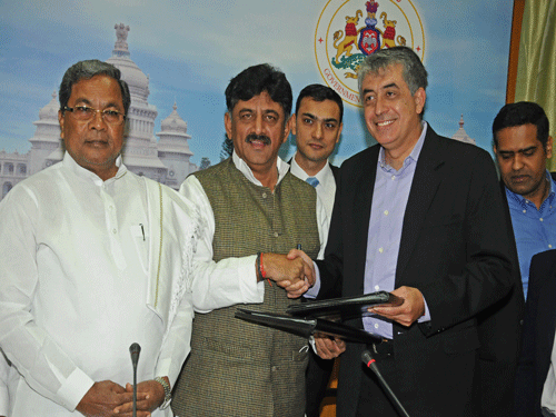 Energy Minister D K Shivkumar and California SunEdison President, CEO Ahmad Chatila exchanging Memorandum of Understanding (MoU) sign between Government of Karnataka through Karnataka Renewable Energy Development Limited (KREDL) and Sun Edison to develop 5000 MW renewable energy within the state for nest 5years at Krishna in Bengaluru on Tuesday. Chief Minister Siddaramaiah, SunEdison Director Rish Thussu and Asia Pacific president Pashupathy Gopalan are seen. DH Photo