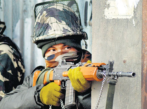 A soldier takes position during an encounter between militants and security forces in north Kashmir's Sopore townon Wednesday. PTI photo