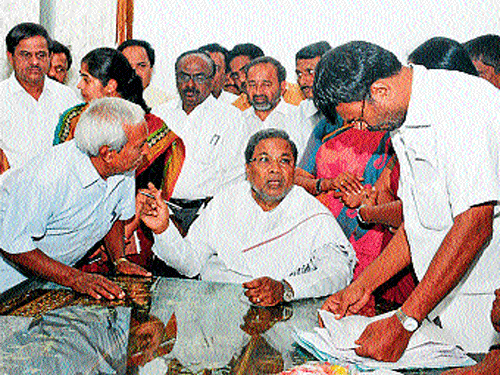 Public contact: Chief Minister Siddaramaiah seen making a point after receiving a petition from an elderly person, in Mysuru, on Saturday. DH Photo