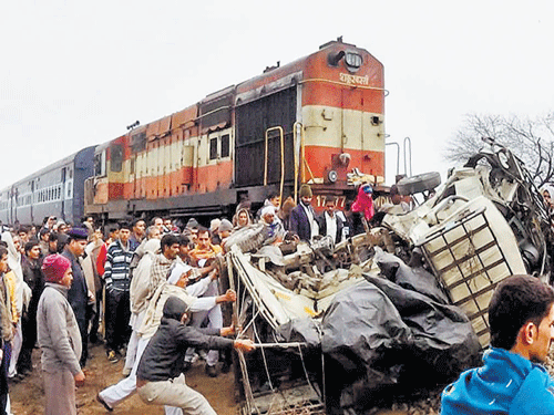 Tragic end: Locals gather at the site of an accident after a passenger train hit a vehicle near Hisar in Haryana on Monday. PTI