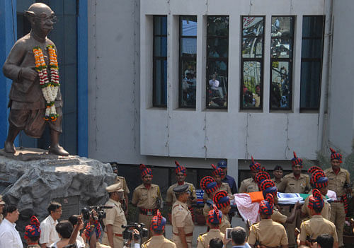 ecurity officers carry the body of acclaimed Indian cartoonist R. K. Laxman. AP photo