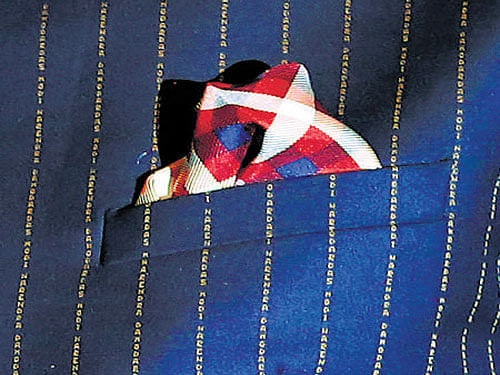 A close-up view of Prime Minister's pinstripe suit, repeatedly embroidered with his own name. REUTERS