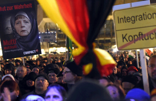 Protestors hold a poster depicting a veiled German Chancellor Angela Merkel and sa ign against headscarfs during a demonstration of Legida, an offshoot of the Pegida anti-Islam movement, in Leipzig, eastern Germany. AP file photo