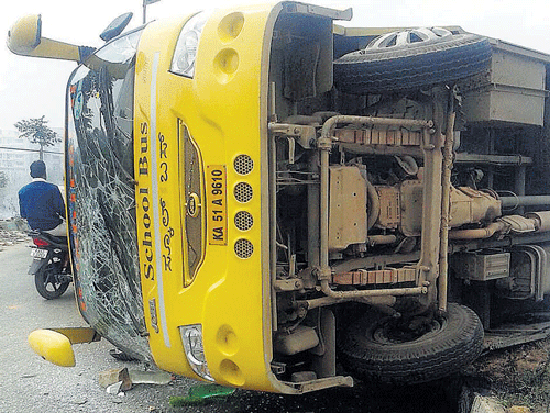 mighty fall: The school bus of Vidyashilp Academy that toppled near Jakkur main road on Thursday. DH Photo