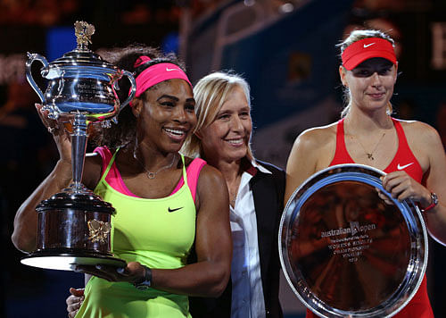 Serena Williams of the U.S., left, holds the trophy with runner-up Maria Sharapova of Russia, right, accompanied by three-time Australian Open champion Martina Navratilova, in the women's singles final at the Australian Open tennis championship in Melbourne. AP photo