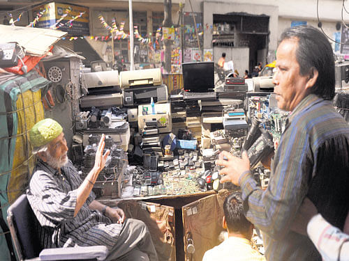 Abdul Gazi sits in his stall amid broken computers and other household appliances at the week-long Bhanga Mela near Kolkata. Debasish Bhaduri