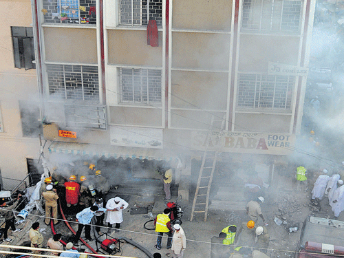 Fire and Emergency Services personnel douse the fire that broke out in a garment godown on  Veerapillai Street (near Commercial Street) in the City  on Saturday. DH photo