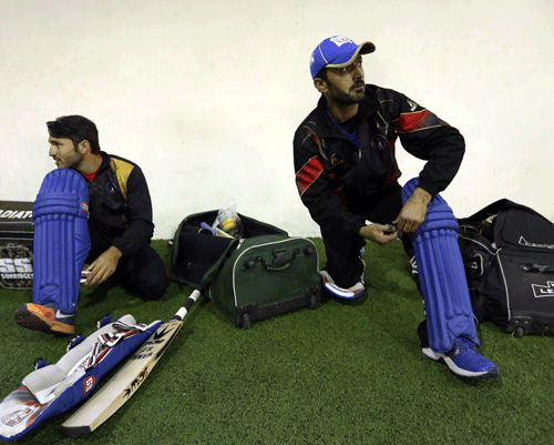 Afghan cricket player Nawroz Mangal, right, puts on his pad during a practice session at Kabul cricket academy training center, in Kabul, Afghanistan, Tuesday, Jan. 27, 2015. The team is preparing to participate in the ICC Cricket World Cup 2015 for the first time, to be held in Australia and New Zealand. As a young cricket team, they face tough matches with the strongest cricket nations of the world, but the team is ready for the challenges laying ahead in the world cup starting mid-February this year, according to the coach and members of the team. AP Photo