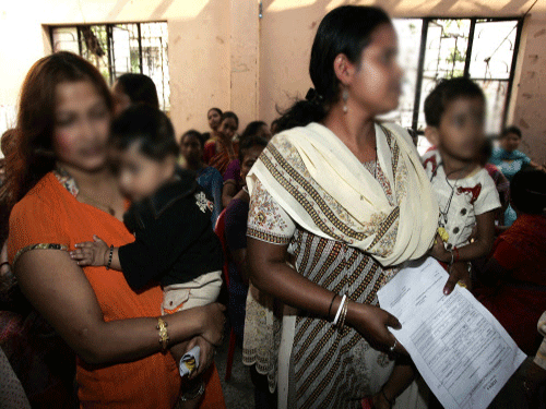 Many cooperative banks in West Bengal may be on the verge of shutting shop, but one such bank continues to be a ray of hope in the darkness of a red-light district in Kolkata. Sex workers stand in queue with their children as they apply for voter identity cards at a camp in red light district Sonagachi. AP file photo