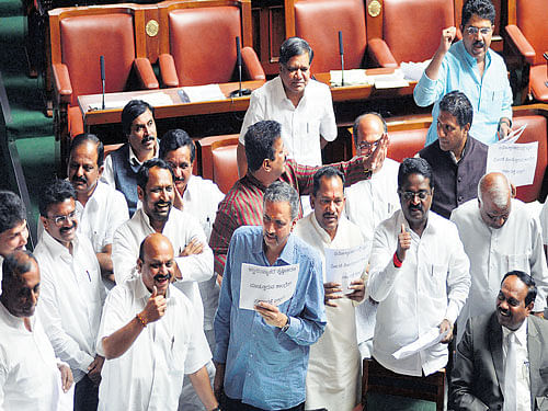 in chorus: BJP members protest against the government's decision to ban the entry of VHP leader Praveen Togadia into Bengaluru, in the Assembly on Wednesday. DH PHOTO