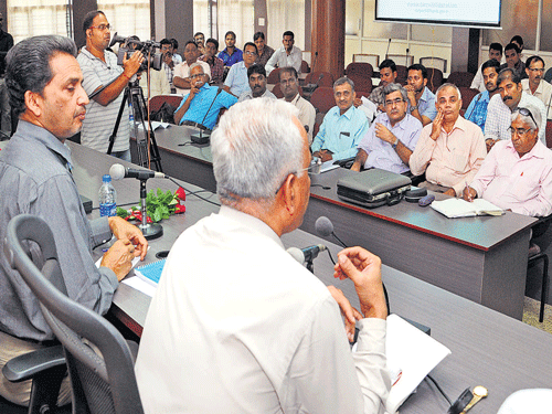 Power Consultant Shankar Sharma speaks at a public consultative meeting to prepare the state action plan on climate change organised by the Karnataka State Pollution Control Board in Mangaluru on Friday. Deputy Commissioner A B Ibrahim looks on. DH&#8200;Photo