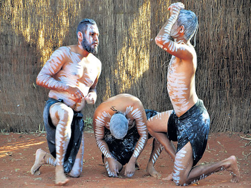rooted An indigenous dance performance near Uluru; (below) a tribal artist at work in central Australia. (photos by author)