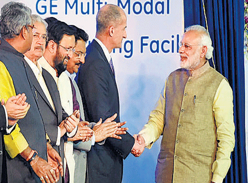 Prime Minister Narendra Modi and General Electric (GE) Vice Chairman John Rice shake hands at the inauguration of the company's plant at Chakan near Pune on Saturday. PTI