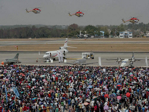 Helicopter team Sarang entertains a large number of visitors witnessing the air show on concluding day of 10th Aero India 2015 in Bengaluru on Sunday. PTI Photo