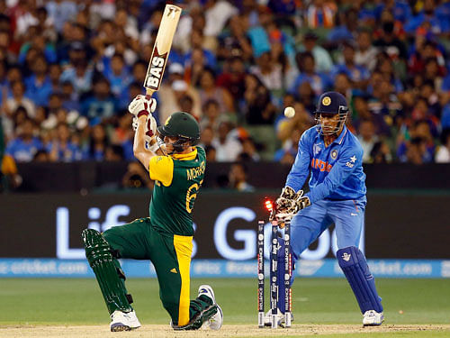 South Africa's Morne Morkel is bowled as India's wicketkeeper MS Dhoni celebrates during their Cricket World Cup match at the MCG. Reuters Photo.