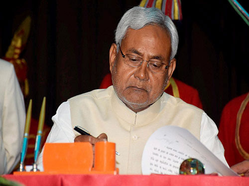JD(U) strongman and former chief minister of Bihar Nitish Kumar signs official documents after taking oath as state's CM for the fourth from Bihar Governor Keshari Nath Tripathi at Raj Bhawan in Patna on Sunday. PTI Photo.