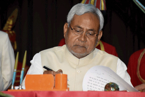 JD(U) strongman and former chief minister of Bihar Nitish Kumar signs official documents after taking oath as state's CM for the fourth from Bihar Governor Keshari Nath Tripathi at Raj Bhawan in Patna on Sunday. PTI Photo