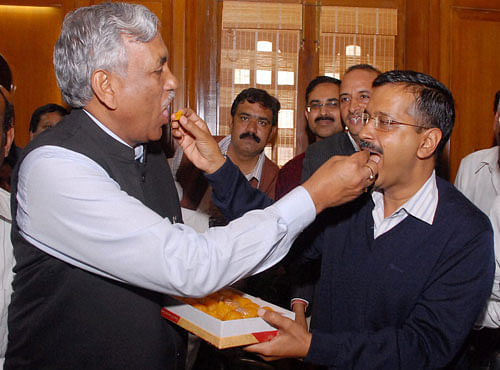 Delhi Chief Minister Arvind Kejriwal exchanges sweets with AAP MLA Ramniwas Goel who was unanimously elected Speaker of the Delhi Legislative Assembly, in New Delhi on Monday. PTI Photo