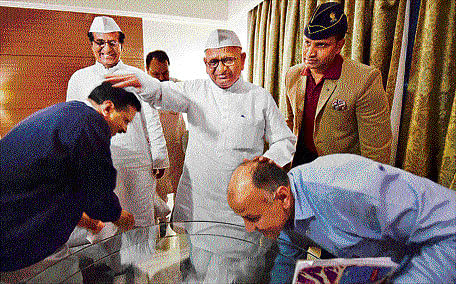 Bless you! Delhi Chief Minister Arvind Kejriwal and his deputy Manish Sisodia seek the blessings of social activist Anna Hazare at a meeting at Maharashtra Sadan in New Delhi on Monday. PTI