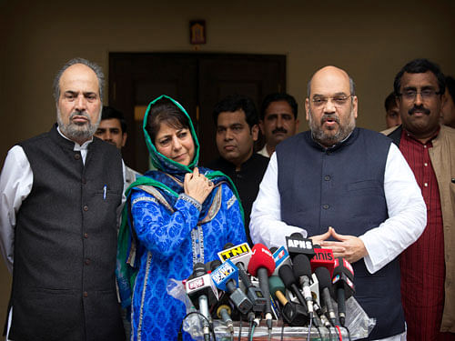 India's ruling Bharatiya Janata Party (BJP) president Amit Shah, right, addresses the media after a meeting with Kashmir's regional Peoples' Democratic Party (PDP) leader Mehbooba Mufti, second left in blue, in New Delhi, India, Tuesday, Feb. 24, 2015. The BJP and the PDP Tuesday finalized an agreement to form a coalition government in Kashmir, the first time the Hindu nationalist party will share a leadership position in the predominantly Muslim region. AP Photo