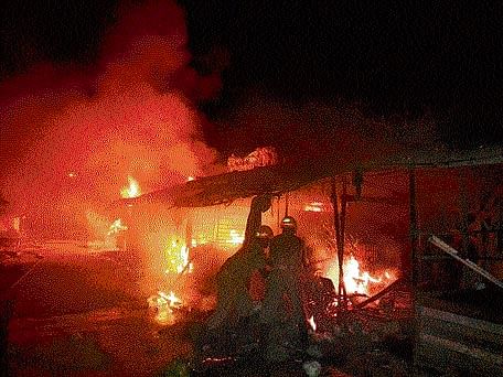 Miscreants set on fire 13 roadside shops near the railway track in Tokkottu near Ullal in Dakshina Kannada district on Thursday.  DH photo