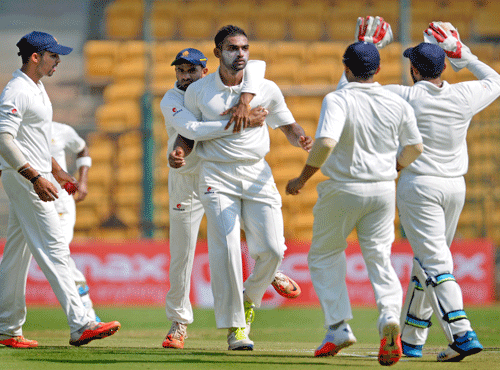 Karnataka's Abhimanyu Mithun exults as his team players celebrates the LBw dismissial of Mumbai's Akhil Herwadkar in the second innings of the on the 3rd days play in the semifinal match in the Ranji Trophy