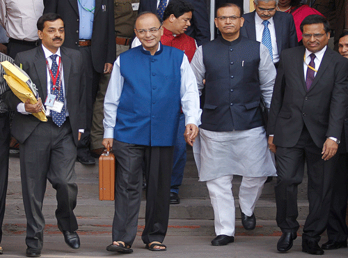 Arun Jaitley, center in blue jacket, display a briefcase containing union budget for the year 2015-16 as he leaves his office for Parliament to present the union budget in New Delhi. AP photo