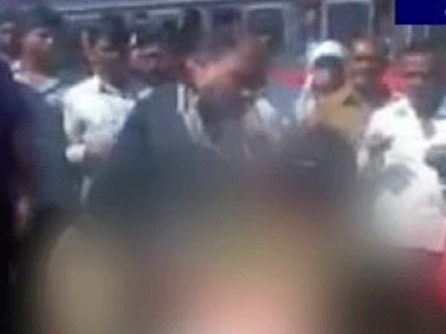 A woman, accused of stealing jewellery of a passenger at a bus stand, was beaten up in full public view allegedly by a policeman, a video of which has gone viral. Screengrab