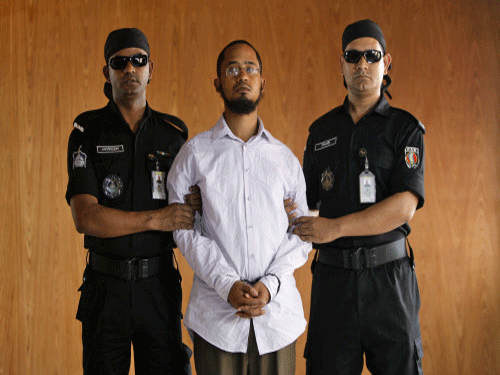 Members of Bangladesh's Rapid Action Battalion (RAB) force escort Farabi Shafiur Rahman, a suspect in the murder of an American blogger Avijit Roy, during his presentation to the media in Dhaka, Bangladesh. Bangladesh security officials say they have arrested a leading suspect in the hacking death of Roy who wrote against religious extremism. AP photo