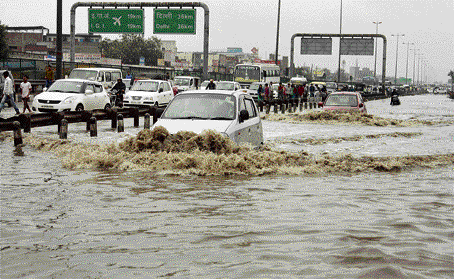 Cars wade through a water-logged stretch of Delhi-Gurgaon Expressway after heavy rain in Gurgaon on Monday. PTI