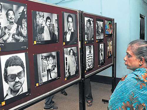 A woman looks at the posters of yesteryear actors  at an exhibition organised to mark Kannada Vakchitra Huttu Habba in Bengaluru on Tuesday. dh photo