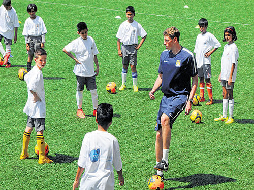 play time A coach from Manchester City academy interacts wth kids during a clinic in the city on Thursday. DH PHOTO