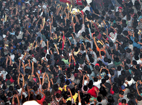 In this Thursday, March 5, 2015 photo, members of a mob raise their hands to take photos of a man, top center, accused of rape after he was lynched and hung in the city landmark Clock Tower in Dimapur, in the northeastern Indian state of Nagaland. AP file photo