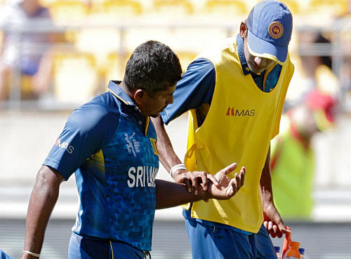 Sri Lanka's Rangana Herath (L) is assisted from the field after injuring a finger while fielding against England during their Cricket World Cup match in Wellington, March 1, 2015. REUTERS file photo