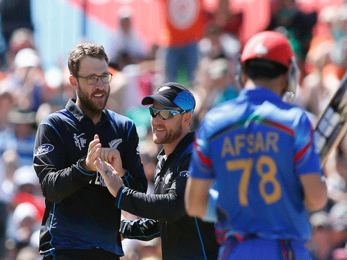 New Zealand's Daniel Vettori (L) and Brendon McCullum celebrate the dismissal of Afghanistan's Afsar Zazai (R) during their Cricket World Cup match in Napier, March 8, 2015. REUTERS photo
