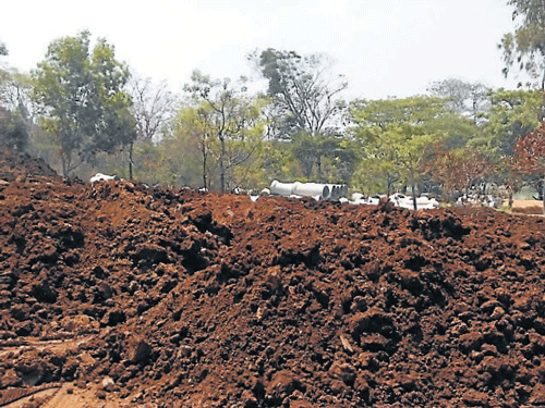 Tonnes of mud which has been dumped inside Kukkarahalli lake premises, in Mysuru.  dh photo