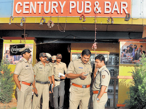 after the attack: Police officials visit Century Pub and Bar following an attack on a few African students by a gang at Byrathi in east Bengaluru on Wednesday. dh Photo